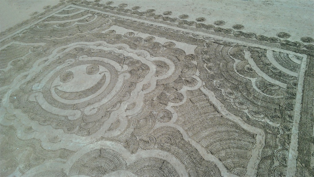 Smiley face pattern in the sand on the beach in Torquay