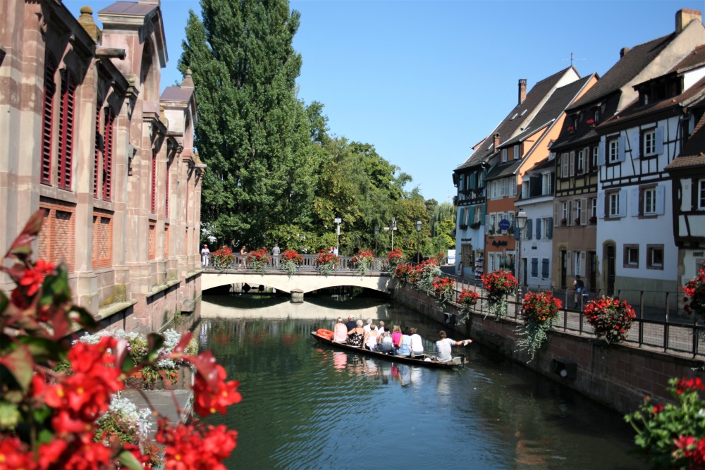 A small boat tours a canal in Colmar, Alsace's little Venice