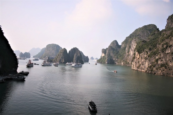 A boat glides through the waters of Halong Bay