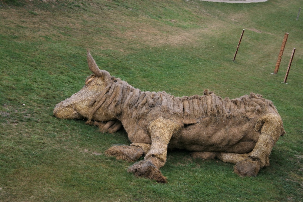 A horse made of straw lies in the grassy moat that runs through the middle of the vauban in Neuf-Brisach