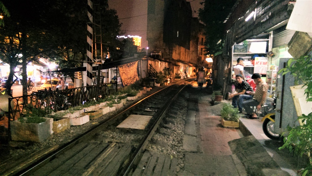 People hanging out beside the railway track in Train Street in Hanoi