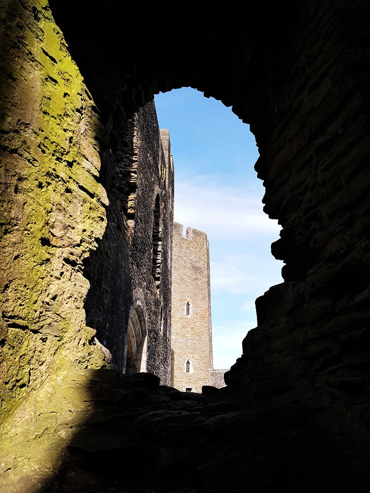 View of Caerphilly Castle through a gap in the wall