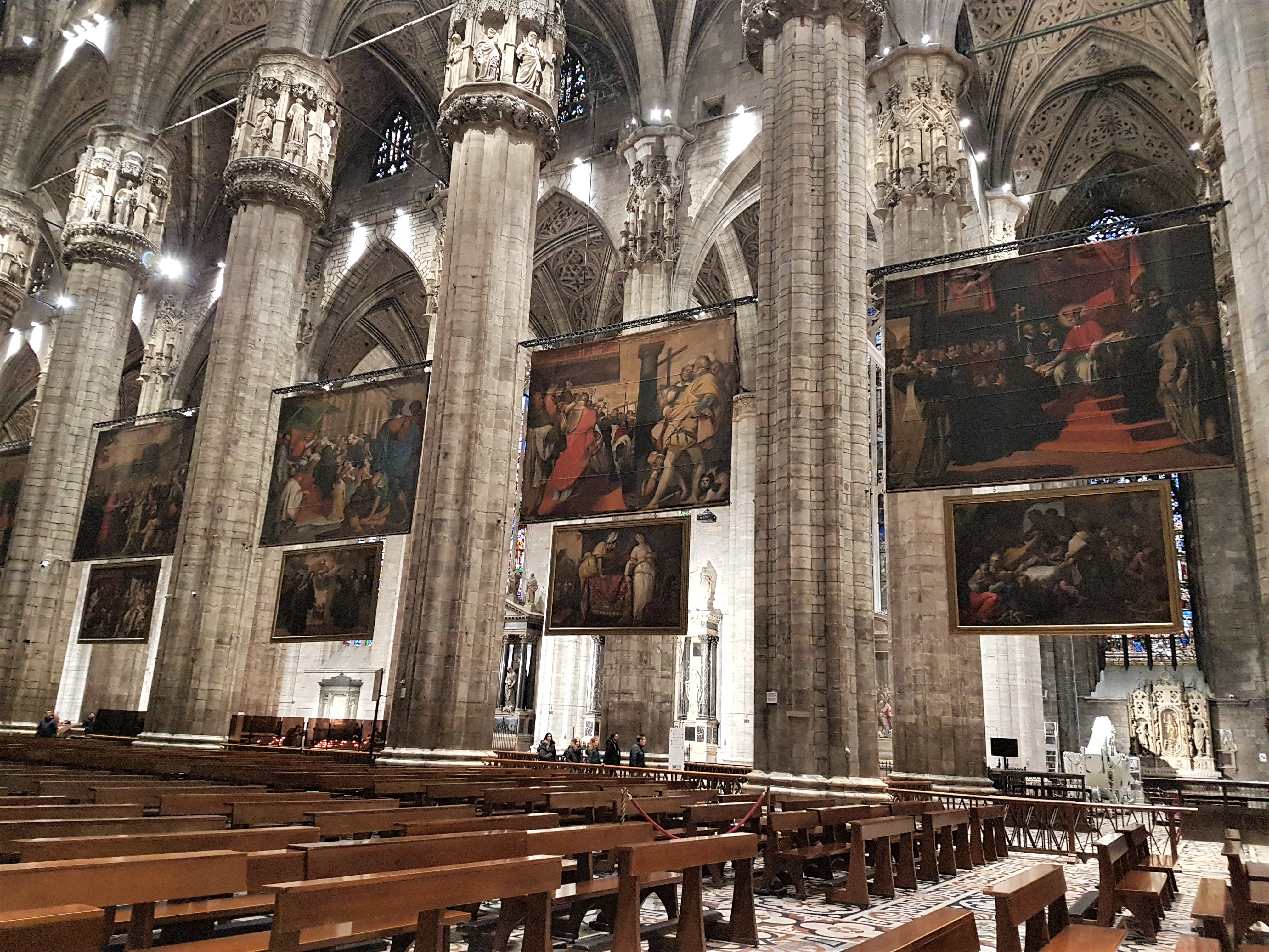 Paintings hanging from the ceiling inside Milan's Duomo
