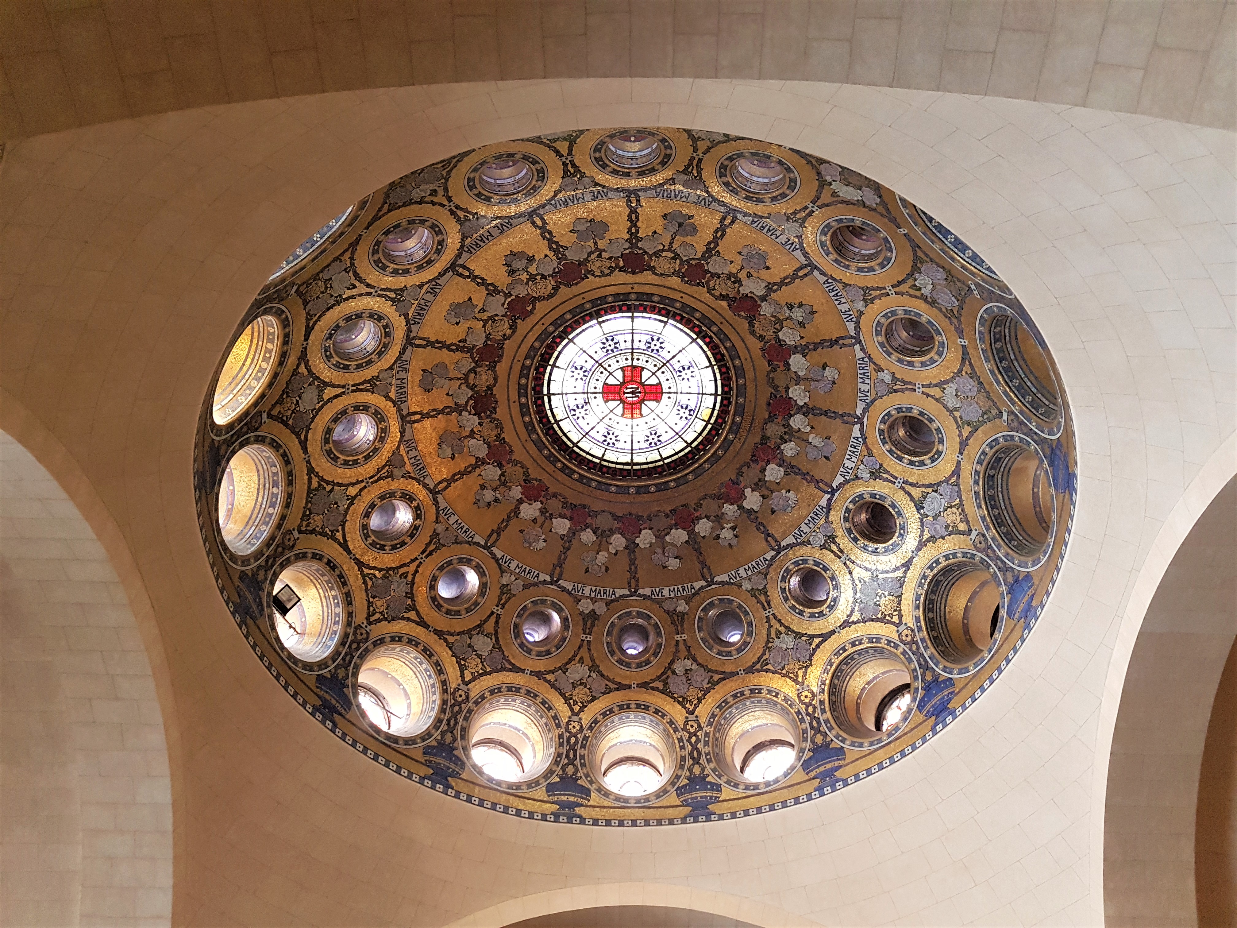 The ornate gold and blue patterned domed ceiling inside the Sanctuary of Our Lady of Lourdes