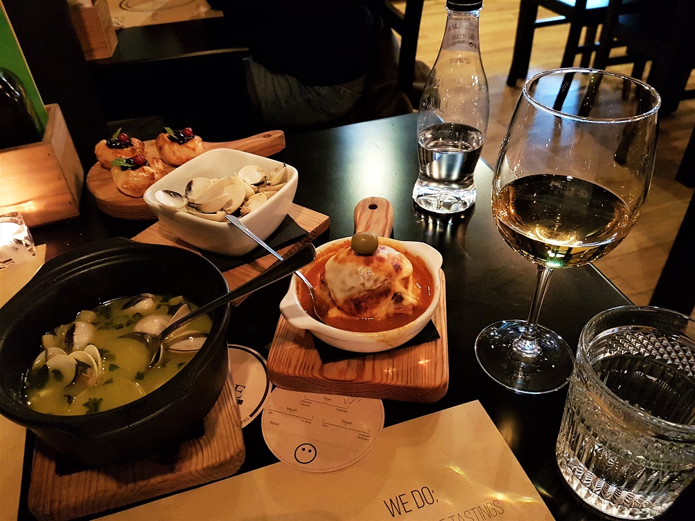 Clams in garlic and coriander, a mini-francesinha sandwich and goat's cheese and redcurrant puffs at The Wine Box bar and restaurant in Porto